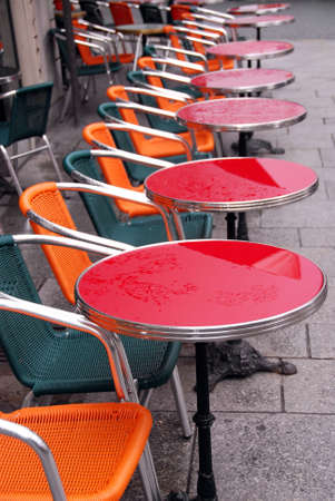 Bright colorful tables in a sidewalk cafe with rain dropsの写真素材