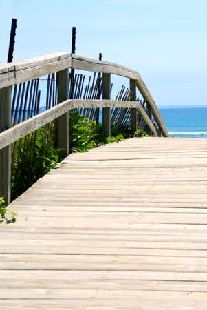 Wooden path over sand dunes with ocean view