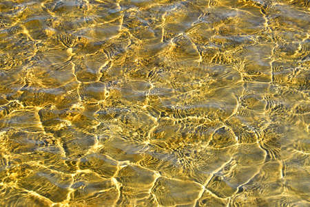 Background of shallow water with ripples and sunshineの写真素材