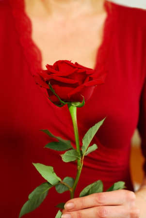 Woman in red holding a red roseの写真素材