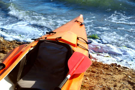 Orange kayak on a sandy shore of a riverの写真素材