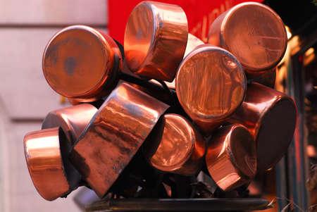 Bunch of old shiny copper pots near a restaurantの写真素材