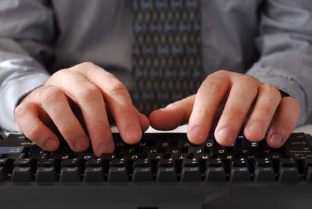 Closeup of man's hands typing on a keyboard