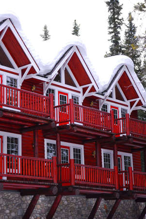 Log building of a mountain lodge in winter at ski resort with snowy roofのeditorial素材