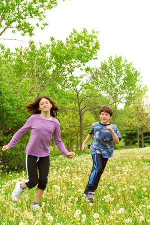 Children brother and sister playing outside in summer parkの写真素材