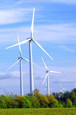Wind power generators in the field against blue sky
