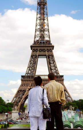 Tourist couple enjoying the view of Eiffel tower in Paris, France.