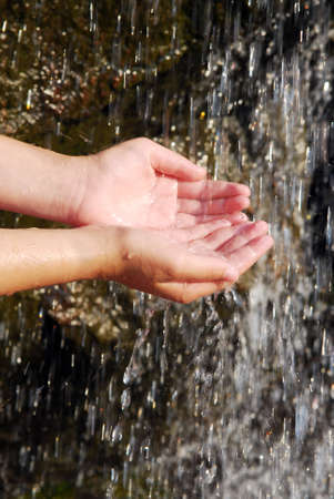Child catching falling water with her hands. Environmental concept.の写真素材