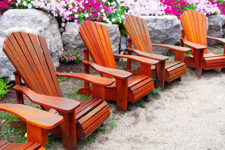 Row of solid wood patio chairs and natural stone landscapingの写真素材