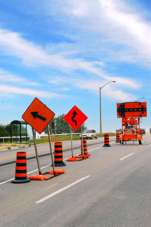 Road construction signs and cones on a city street