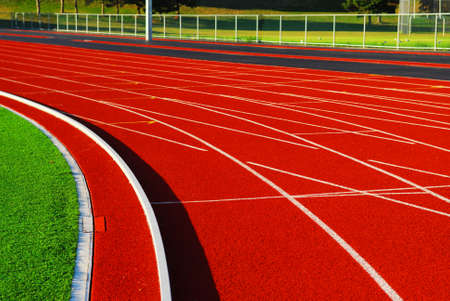 Curving lanes of a red racetrack in a stadium