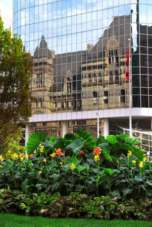 Reflection of old Toronto city hall building in a glass wall of a modern highrise の写真素材