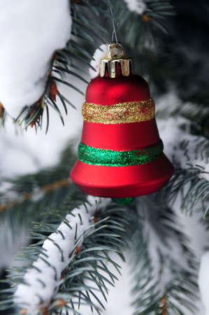 Christmas decoration hanging on snow covered spruce tree outsideの写真素材