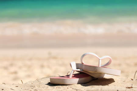 Flipflops on a sandy ocean beach - vacation conceptの写真素材