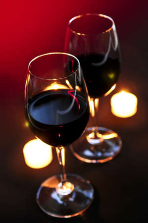 Two wineglasses with red wine at candlelightの写真素材