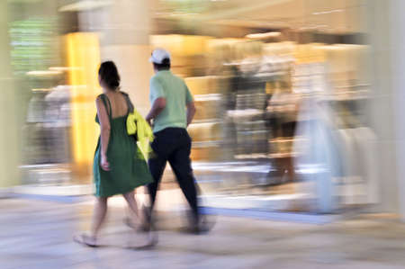Couple shopping in a mall, panning shot, intentional in-camera motion blurの写真素材