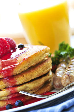 Breakfast of buttermilk pancakes with sausages and fresh berriesの写真素材