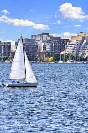 Sailboat sailing in Toronto harbour with scenic waterfront viewの写真素材