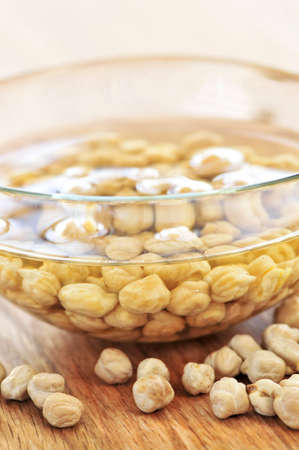 Dry raw chickpeas soaking in water before cookingの写真素材