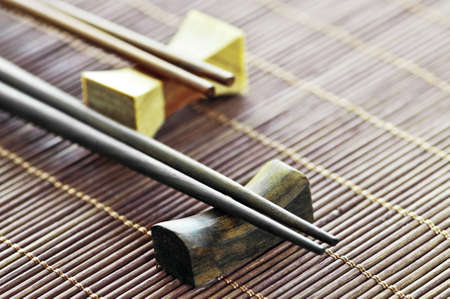 Two sets of wooden chopsticks on rests close up