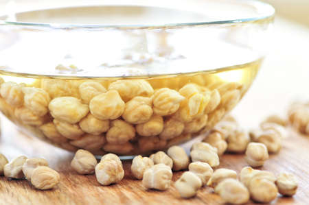 Dry raw chickpeas soaking in water before cookingの写真素材