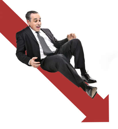 Businessman sliding down red arrow in financial crisisの写真素材