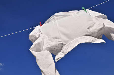 White shirt hanging to dry on clothes lineの写真素材