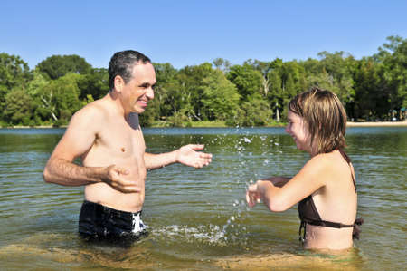 Father and daughter splashing in a lakeの写真素材