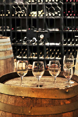 Row of wine glasses on barrel in winery cellar