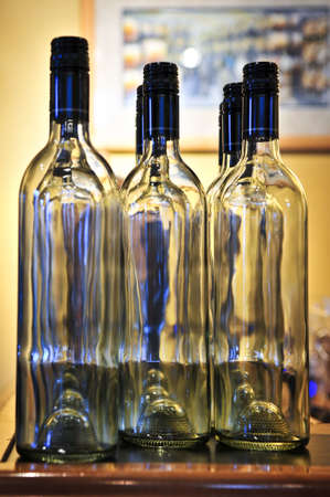 Empty clear wine bottles with blue capsの写真素材