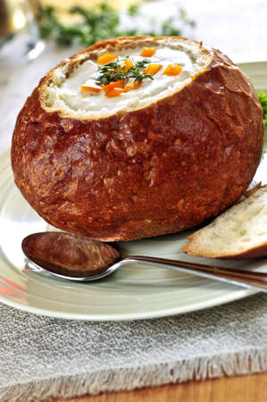 Lunch of soup served in baked round bread bowl
