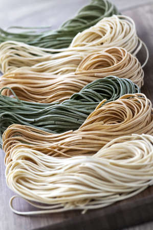 Assorted bundles of colorful raw tagliolini pasta noodlesの写真素材