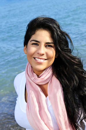 Portrait of beautiful smiling brunette girl at beachの写真素材