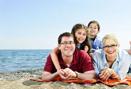 Happy family laying on towel at sandy beach