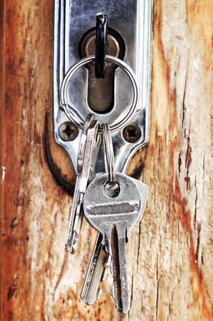 Set of keys in lock of old wooden door