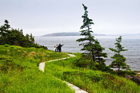 Father and children standing at Atlantic shore in Newfoundland, Canadaの写真素材