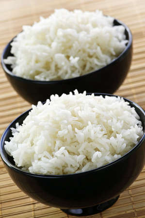 White steamed rice in two black round bowlsの写真素材