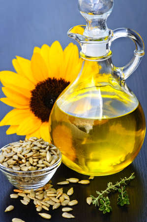 Sunflower oil bottle with raw seeds and flowerの写真素材