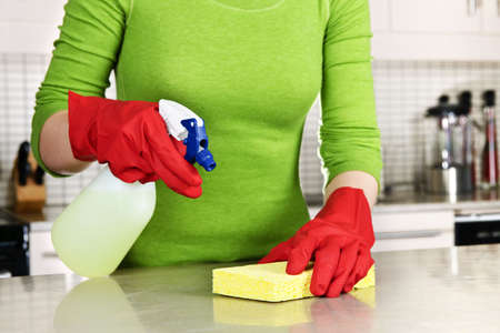 Girl cleaning kitchen  with sponge and rubber gloves