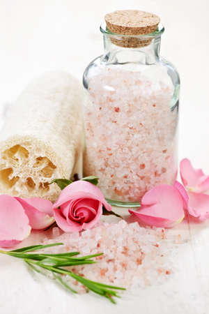 Pink bath salts in a glass jar with flowers and herbsの写真素材