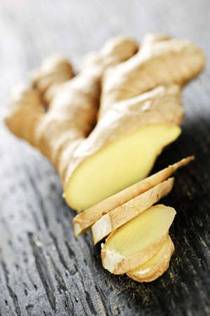 Close up of sliced fresh ginger root spice on wooden tableの写真素材