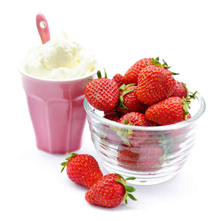 Bowl of fresh organic red strawberries with whipped creamの写真素材