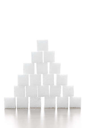 Pyramid of white sugar cubes stacked up on white backgroundの写真素材