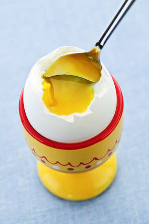 Closeup of soft boiled egg in cup with spoonの写真素材