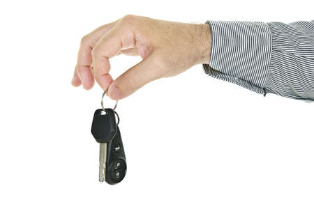 Hand holding car key and remote entry fob isolated on white backgroundの写真素材