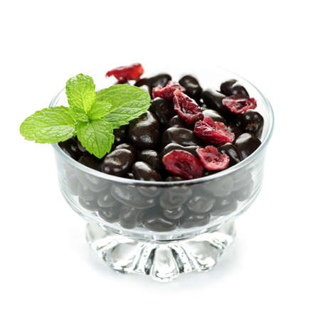 Chocolate coated cranberries in glass bowl on white backgroundの写真素材