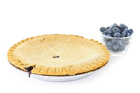 Whole blueberry pie with fresh wild blueberries isolated on white backgroundの写真素材
