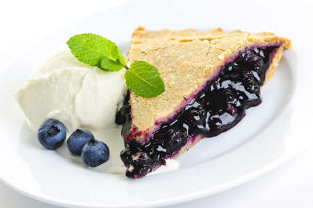Slice of blueberry pie with vanilla ice cream and berriesの写真素材