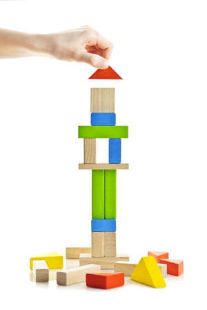 Hand building tower of wooden blocks isolated on white backgroundの写真素材