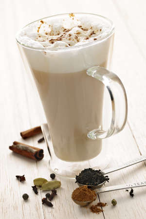 Chai latte spiced tea beverage in glass mug with spicesの写真素材